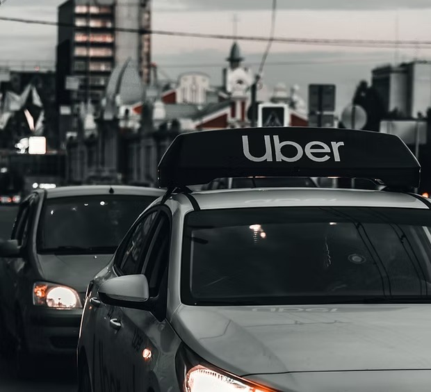 A car with an Uber sign driving in traffic