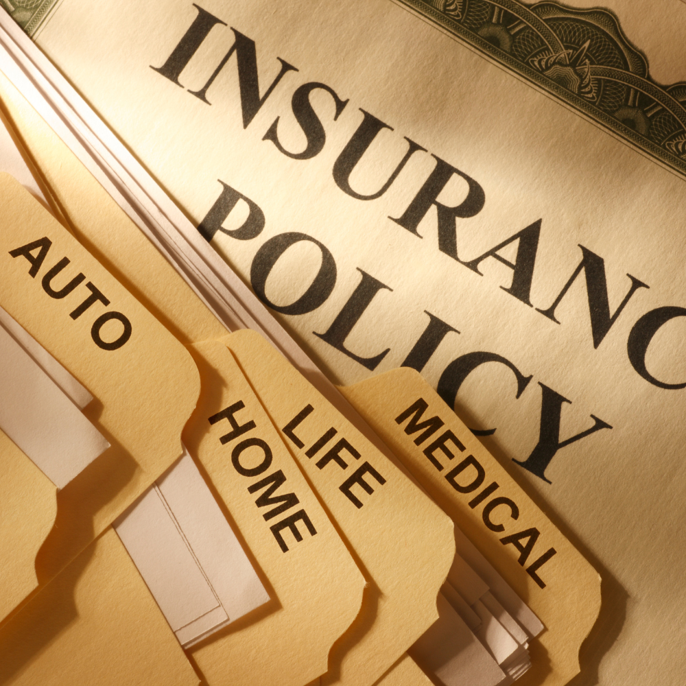 Manilla folders titled Insurance Policy, Medical, Life, Home, and Auto