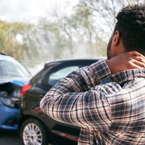 A man rub his neck in pain after getting into a rear-end car accident