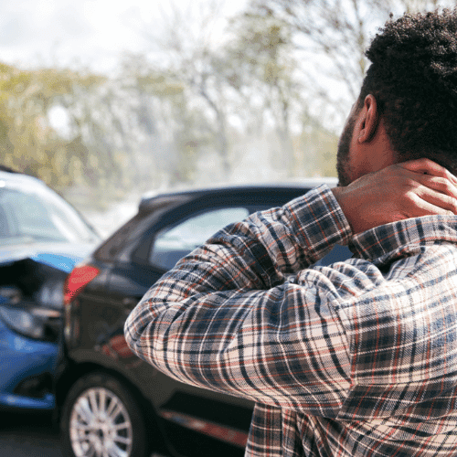 A man rub his neck in pain after getting into a rear-end car accident