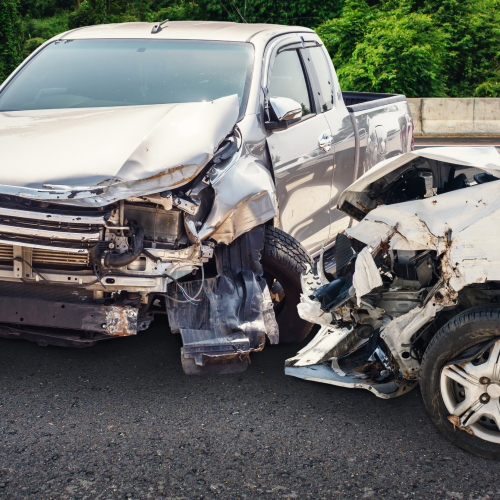 Two vehicles involved in a head-on car collision with wreckage on the front fenders