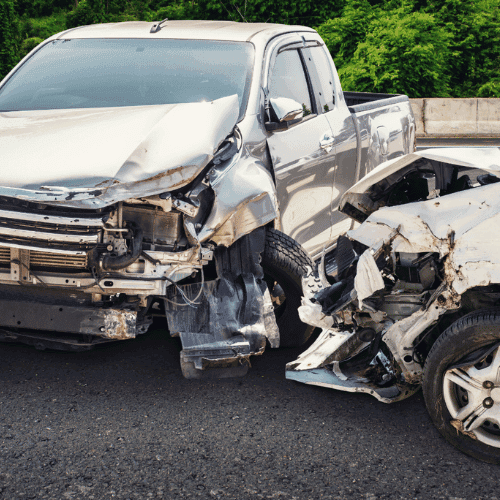 Two vehicles involved in a head-on car collision with wreckage on the front fenders