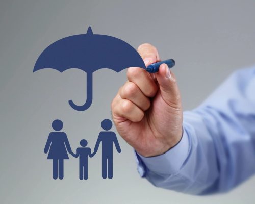 A symbol is being drawn with a blue marker showing an umbrella over a woman and man and child, signifying insurance coverage